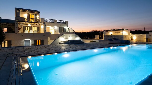 Uma villa moderna com piscina, área de estar coberta ao ar livre e entrada bem iluminada.