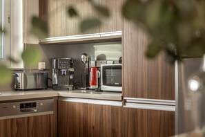 A kitchen with wooden cabinets, a toaster, a coffee maker, and a microwave.