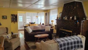 Una sala de estar acogedora con chimenea, un sofá, una mesita de centro y una estantería.