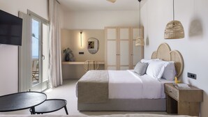 A modern bedroom with a bed, bedside tables, a ceiling fan, and a TV. - Morfes Luxury Suites by Caldera Houses (Santorini)