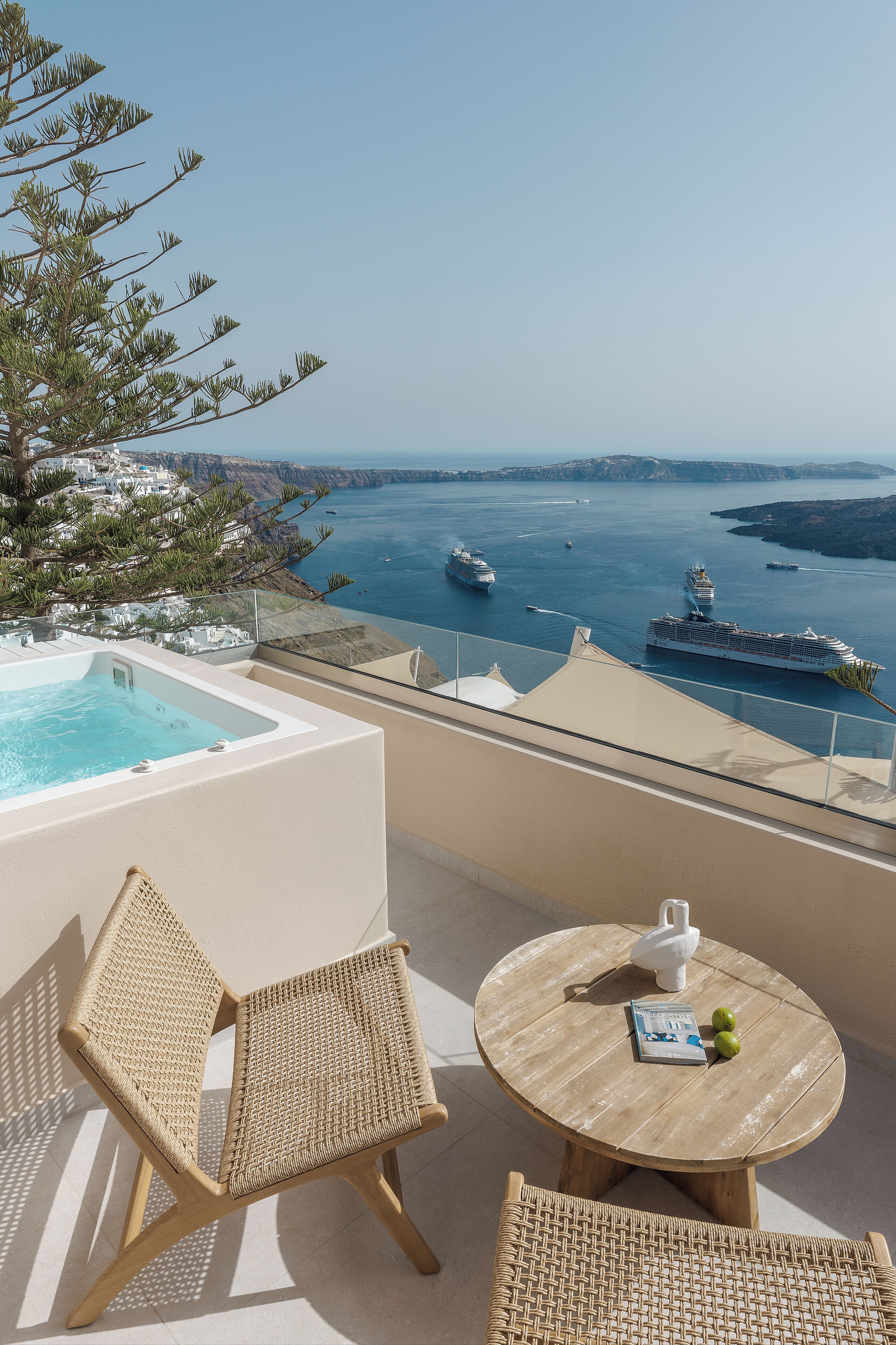 Ein Balkon mit Meerblick, einem Whirlpool und Korbmöbeln.