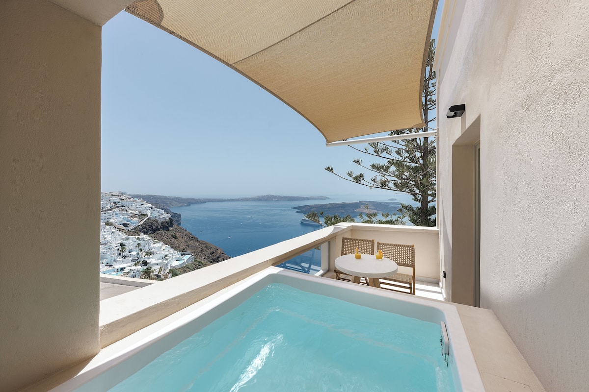 Un balcón con vistas al mar, una piscina pequeña y una mesa con sillas.