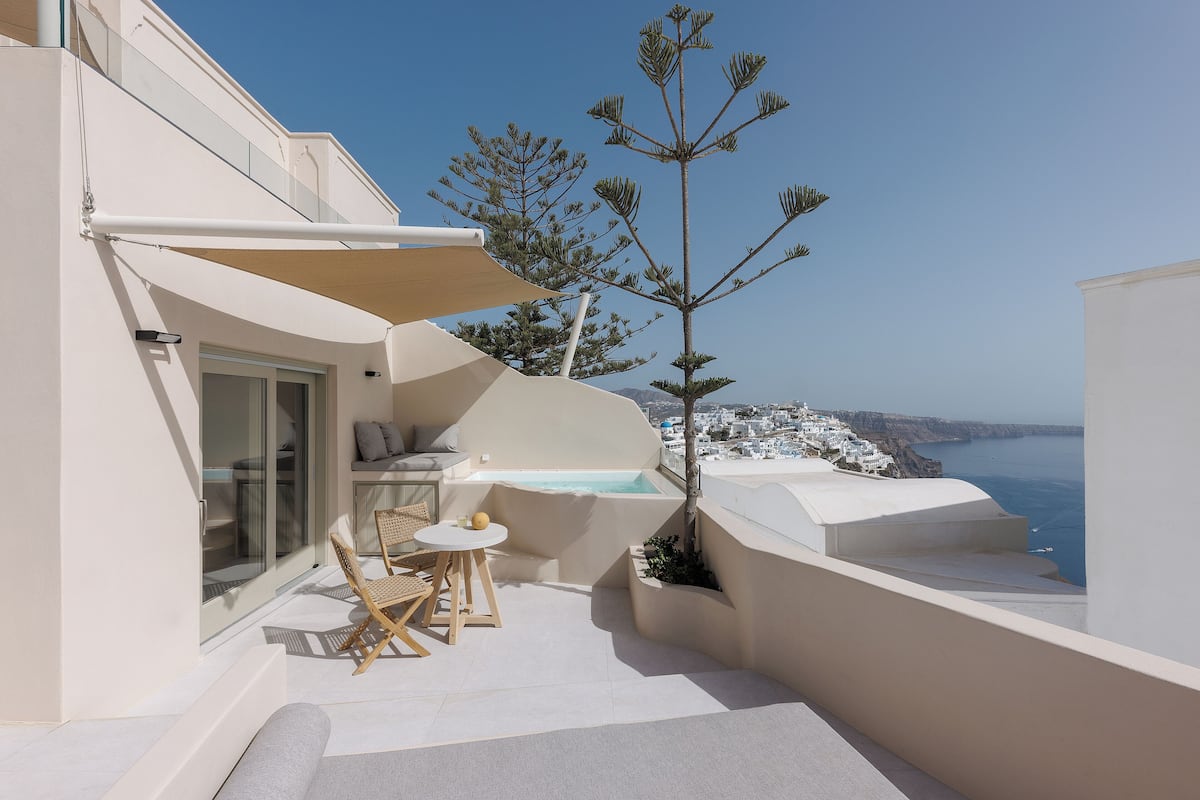 Un balcón moderno con una zona de estar, una mesita y vistas al mar.
