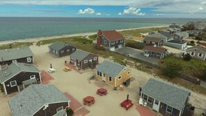 A coastal residential area with houses, a sandy beach, and the ocean in the background. - Beachland K (Sandwich)
