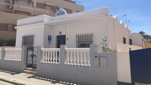 A white building with a sign reading "avenida" and a blue "H" sign, indicating a hotel. - Hostal Avenida by Bossh! Hotels (Chipiona)