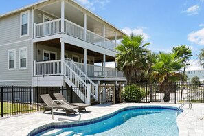 A two-story building with a balcony, a swimming pool, and lounge chairs. - Cape Dreamin' (Port St. Joe)