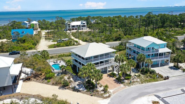 A coastal property with a pool, multiple buildings, and a view of the ocean. - Cape Dreamin' (Port St. Joe)