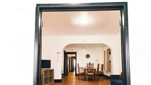 A hallway with a wooden floor leading to a dining area with a table and chairs. - Best in Buffalo Entire First Floor up to 6 guests (Buffalo)