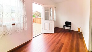 A room with wooden flooring, a white door, and a black chair. - Best in Buffalo Entire First Floor up to 6 guests (Buffalo)