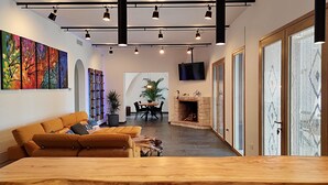 Ein modernes Wohnzimmer mit einer Couch, einem Essbereich und einem Kamin.