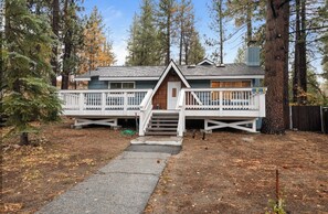 A cabin with a front porch, a staircase, and a deck.