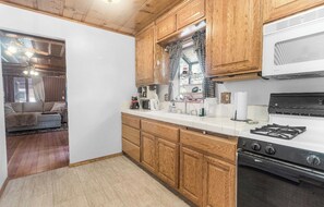 A kitchen with wooden cabinets, a stove, and a microwave.