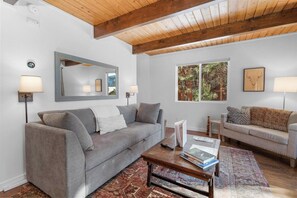 A living room with two sofas, a coffee table, and a large mirror. - Wondrous Juniper House (Big Bear Lake)