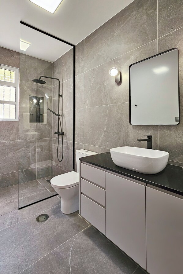 A modern bathroom with a glass-enclosed shower, a white sink, and a large mirror. - A peaceful, relaxing place with privileged view of the sea. (Tabua)
