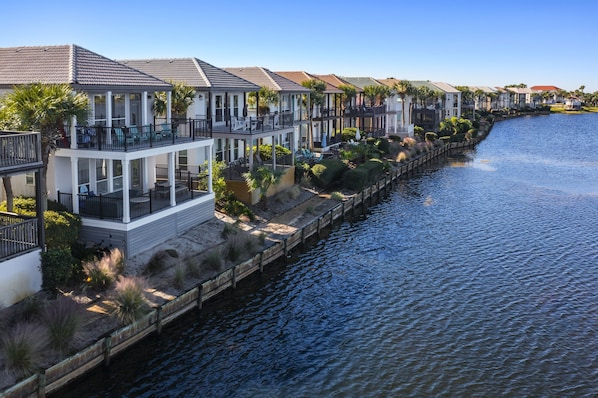 A waterfront property with multiple-story houses, a dock, and a canal. - Waterfront Villa~Beach~Pool-King Beds (Destin)