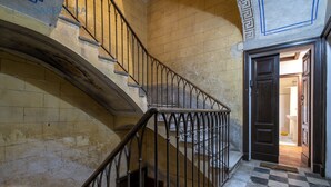 A staircase with a checkered floor and a dark door at the bottom. - ClickSardegna Casa Carlo Alberto In the Heart of Catalan Alghero near the beach (Alghero)