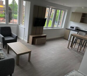 Apartamento Deluxe | Zona de estar | Smart TV de 40 pulgadas con canales por cable