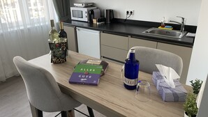 Una cucina moderna con un tavolo da pranzo, sedie, un forno a microonde, un lavello e una pianta in vaso.