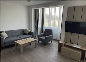 Deluxe Apartment | Living area | 40-inch Smart TV with cable channels