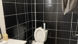 A bathroom with a toilet, sink, and shower area. - T1 Vieux Port Opera (Marseille)