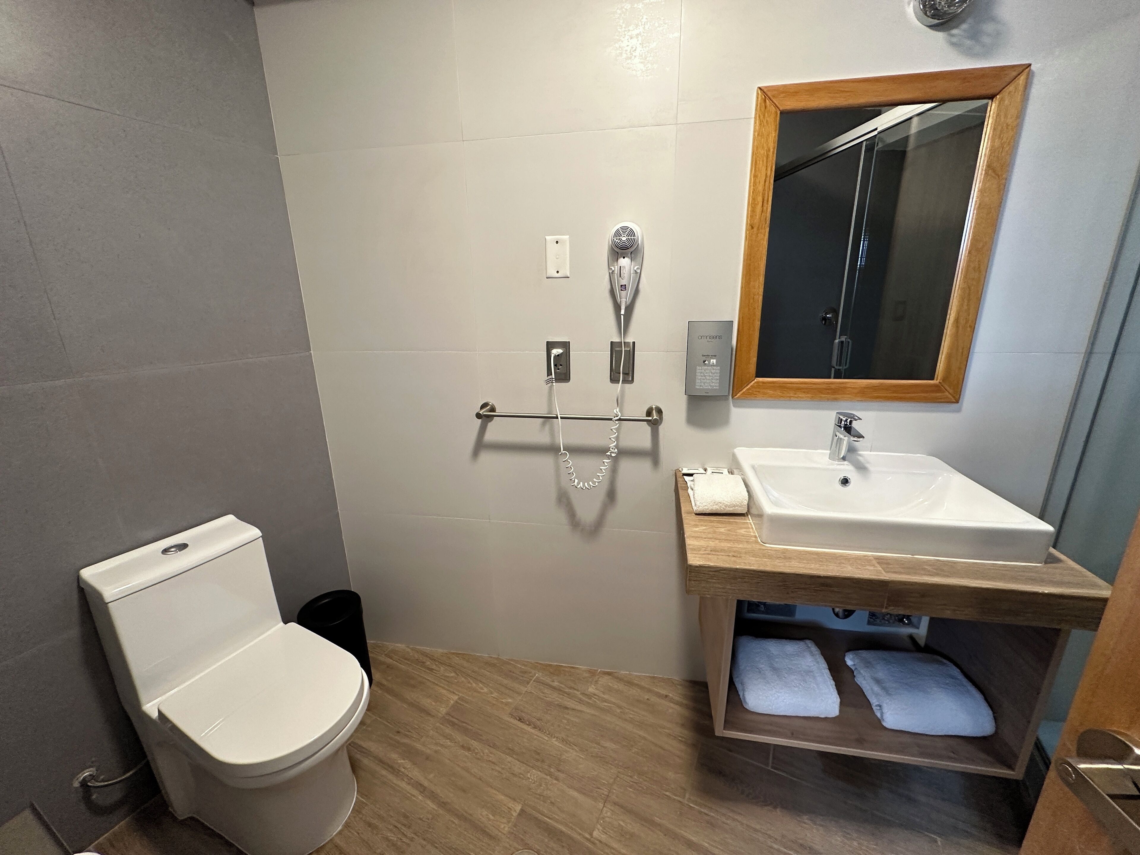 Un baño moderno con inodoro, lavamanos y ducha.