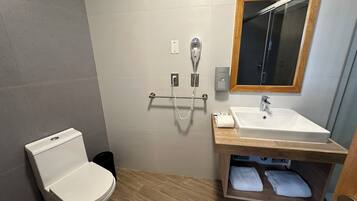 Un baño moderno con inodoro, lavamanos y ducha.