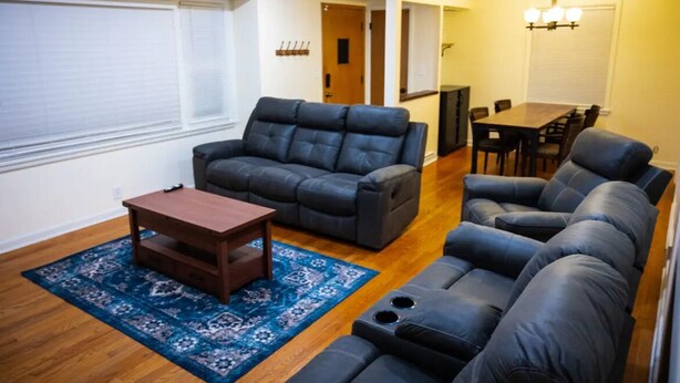 A living room with a sofa set, a coffee table, and a dining table. - Warm spacious midsize home w/ comfort and fun (Glendale)