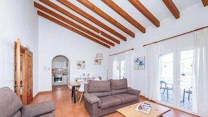 Un soggiorno con divano, un tavolino in legno e un'area pranzo con tavolo e sedie.