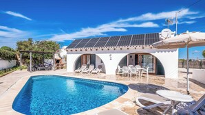A swimming pool with lounge chairs and a covered patio area. - Villa Chiquita - Three Bedroom Villa, Sleeps 4 (Cala en Porter)