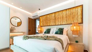 Une chambre moderne avec un grand lit, des lampes de chevet, un miroir et un panneau mural en bambou.