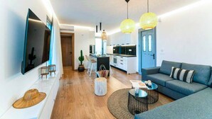 Un salon moderne avec un canapé, une table basse et un téléviseur fixé au mur.
