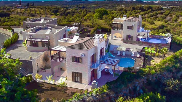 Área residencial com vários edifícios, incluindo uma casa com piscina e vista para o mar.