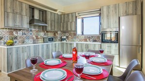 A modern kitchen with wooden cabinets, a built-in oven, and a refrigerator. - Villa Ourania Klio - Two Bedroom Villa, Sleeps 4 (Crete)