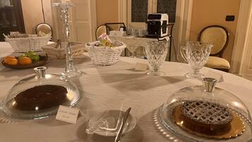 A dining table set with glassware, plates, and a coffee machine.