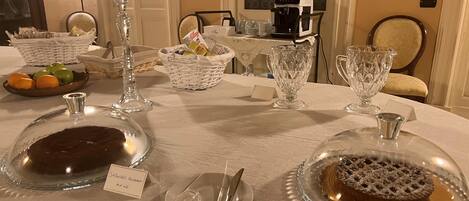 A dining table set with glassware, plates, and a coffee machine.