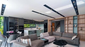 Un espace de vie moderne comprenant une cuisine, un coin repas et un espace détente avec un canapé et une table basse.