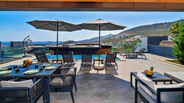Un espace extérieur aménagé pour les repas, avec une piscine, des parasols et des chaises longues.