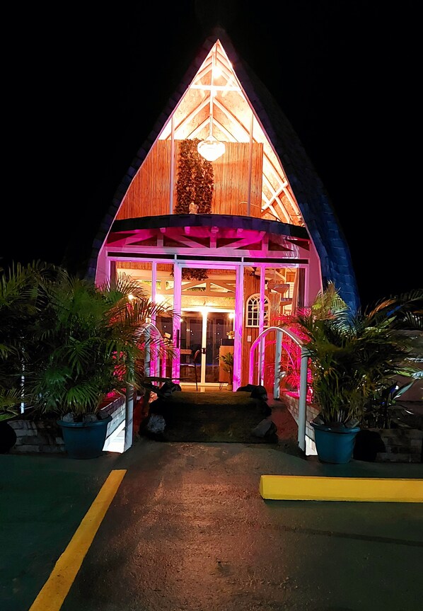 A building with a triangular roof and a porch area.