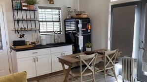 Ein kompakter Wohnraum mit Küchenzeile, Essecke und einer Sitzecke mit Sofa und Couchtisch.