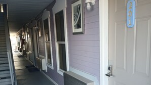 Un corridoio d'albergo con diverse porte, un zerbino blu con la scritta 'blessed' e un cartello che indica la stanza numero 201.