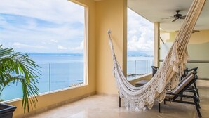 Una habitación con hamaca, vista al mar y ventilador de techo.