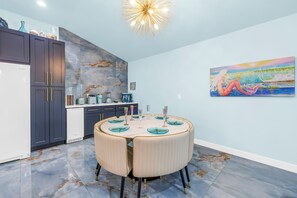 Eine moderne Küche mit Einbaukühlschrank, dunklen Schränken und einer Marmor-Spritzschutzwand.