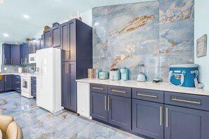 A modern kitchen with dark cabinets, a white refrigerator, and a marble backsplash. - Luxury Mermaid House
 (Largo)