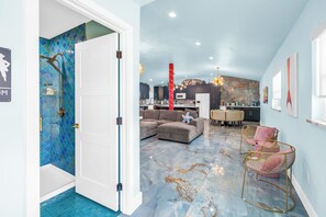 A modern interior with a living area, kitchen, and a bathroom with a unique blue tile design. - Luxury Mermaid House
 (Largo)