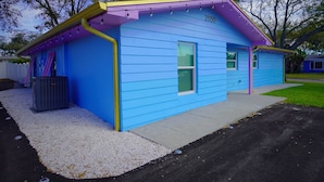 Une maison bleue avec le numéro 2050 sur le côté, une petite fenêtre et une porte.