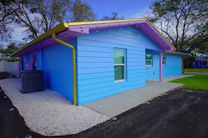 Ein blaues Haus mit der Hausnummer 2050, einem kleinen Fenster und einer Tür.