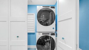 Une buanderie équipée de deux machines à laver Whirlpool à chargement frontal, superposées.