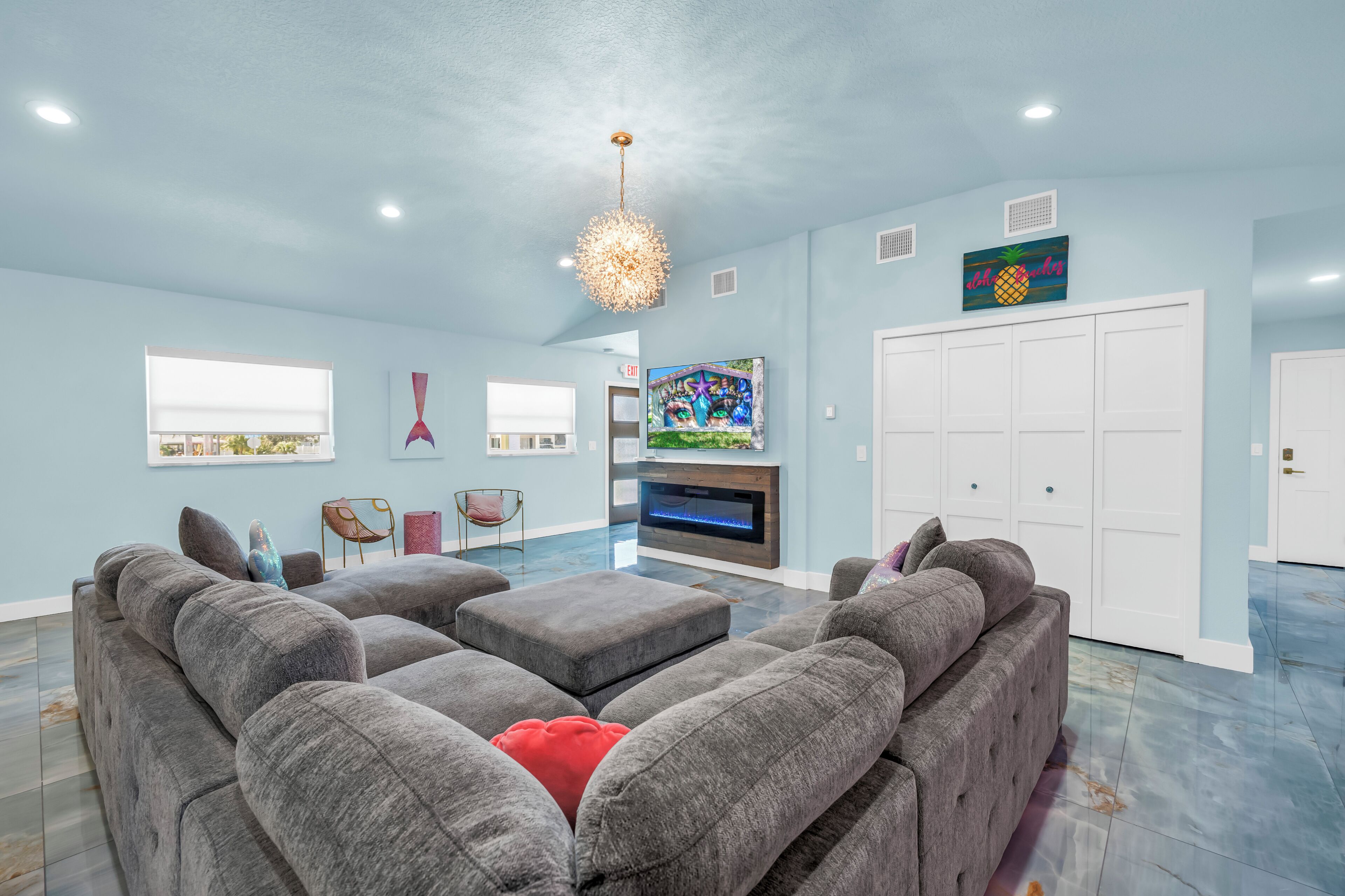 A modern living room with a sectional sofa, a fireplace, and a large TV.