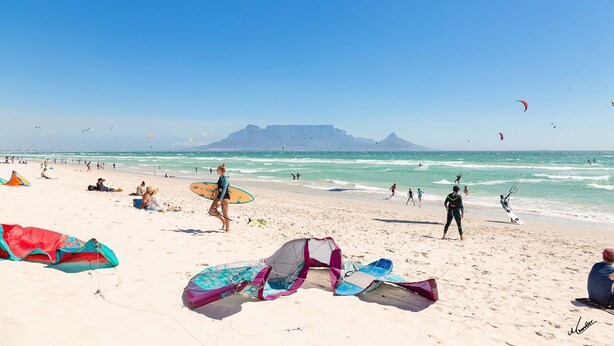 A beach with people, kites, and surfboards. - Sea Spray AG04 - Two Bedroom Apartment, Sleeps 4 (Cape Town)