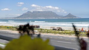 A coastal road with a view of a mountain and the ocean. - Sea Spray B104 - Studio Apartment, Sleeps 2 (Cape Town)